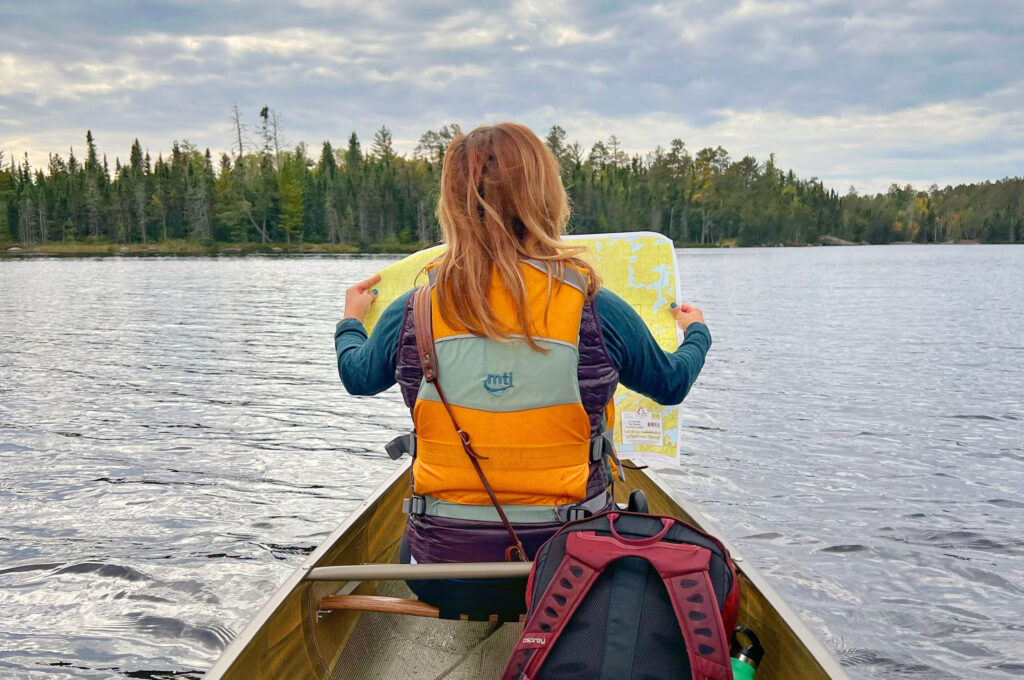 Woman reading map in canoe